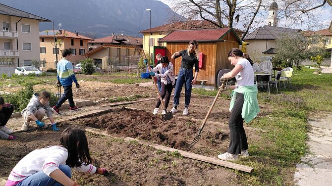 Due studenti curano l'orto sotto la supervisione dell'insengnate